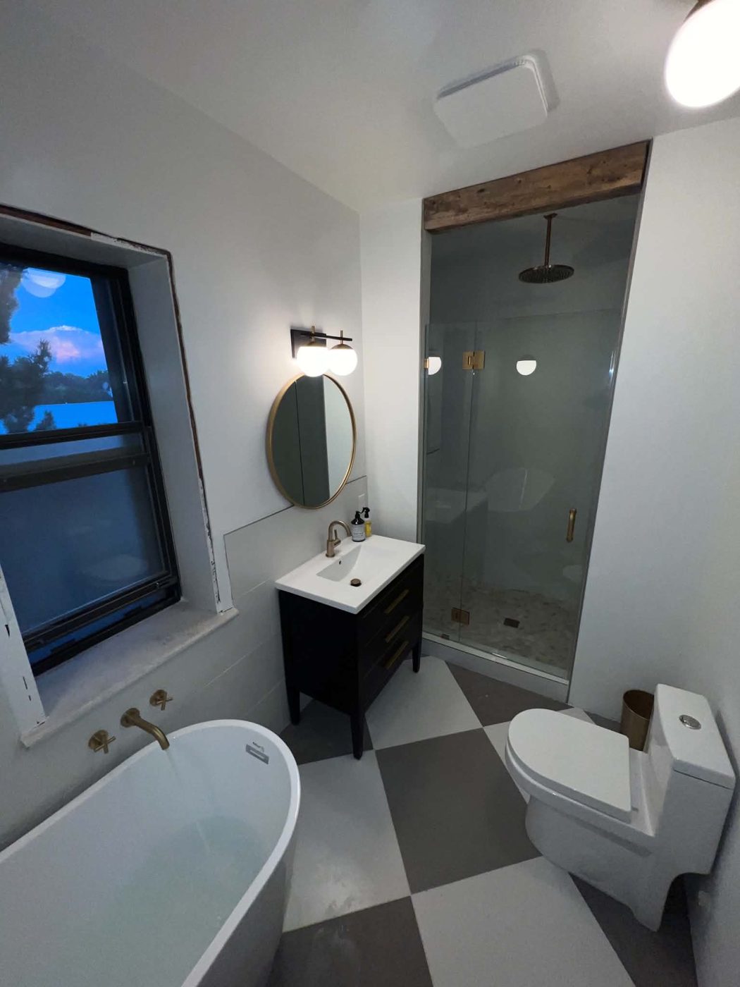 Renovated bathroom with freestanding tub, walk-in shower, and dark vanity