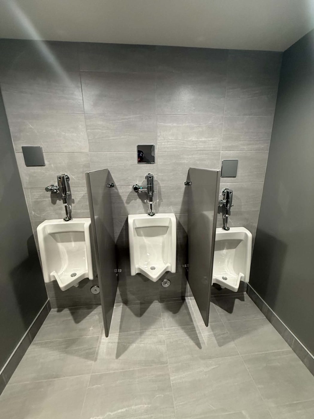 Three-stall commercial restroom with wall-mounted urinals