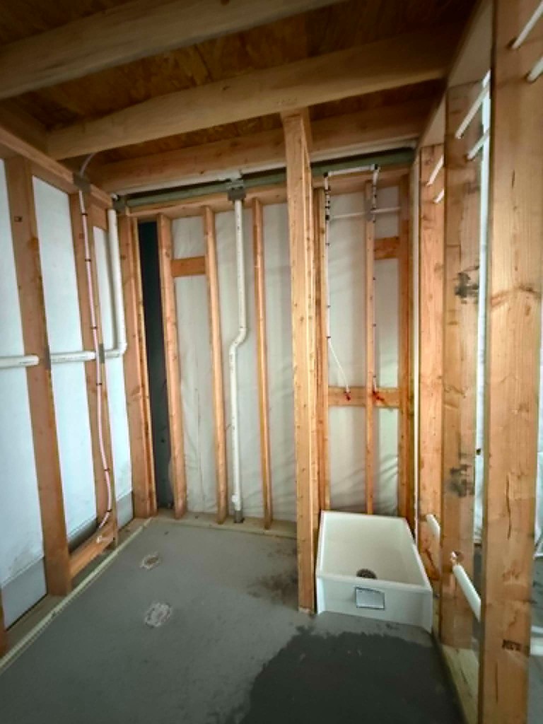 Framed utility area with rough plumbing and sink basin set
