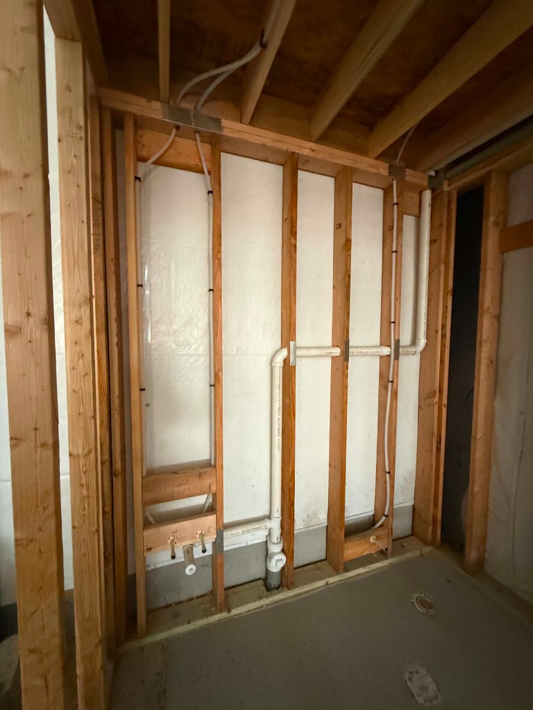 Wall plumbing rough-in with vertical drains and vent stack