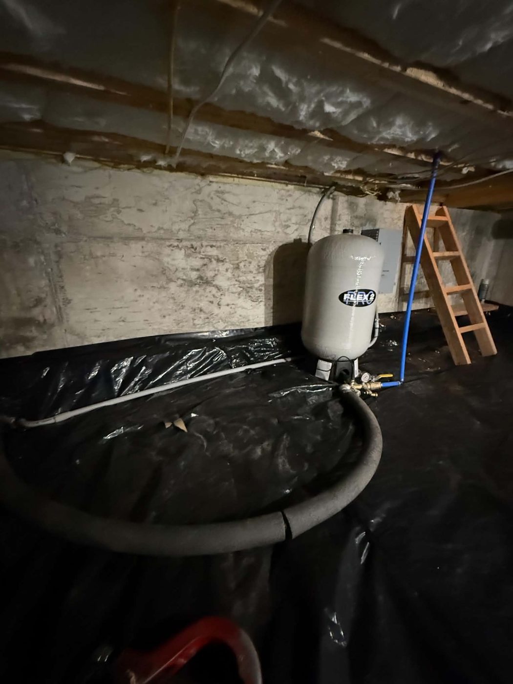 Water pressure tank installed in a crawl space with supply lines