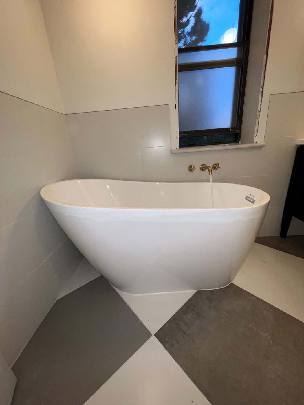 Freestanding tub with brushed brass wall-mounted faucet